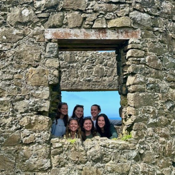 Students looking through a window on an old abandoned Irish castle